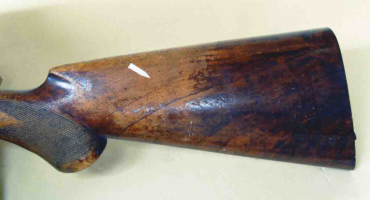 This old Lefever double gun stock was finished with lacquer or shellac. The light area (arrow) is bare wood, due to the finish flaking off. The rest of the stock shows the colored finish that remains.
